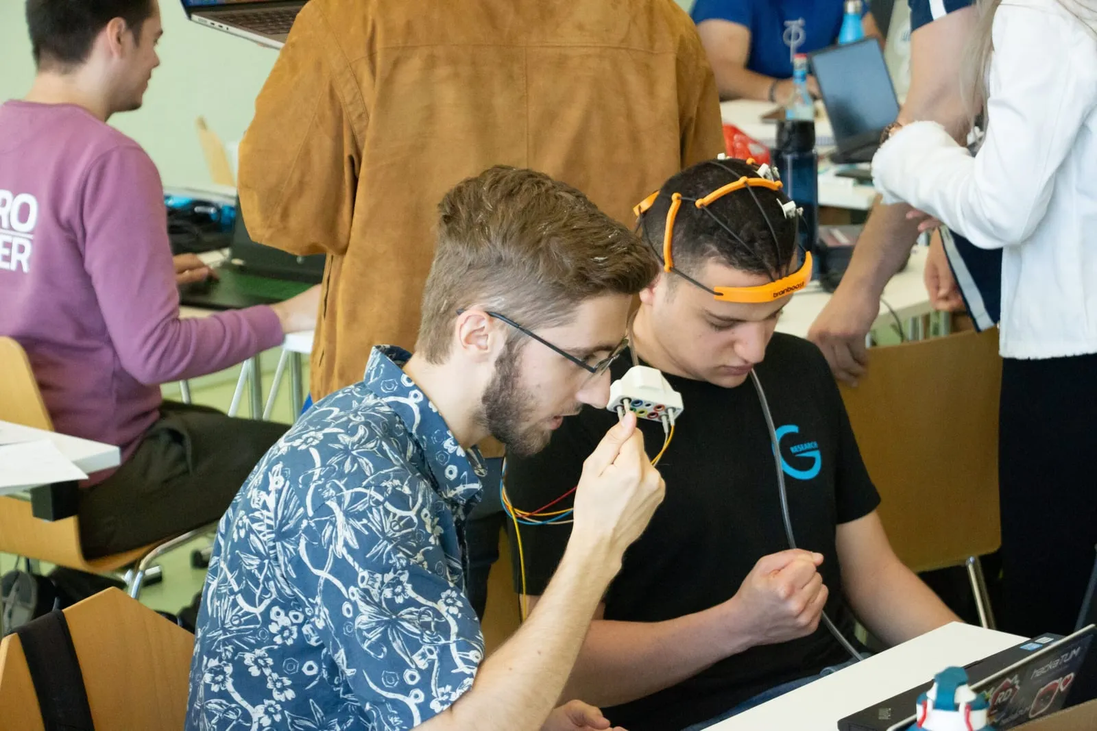 Hackathon participants testing a brainboost EEG headset